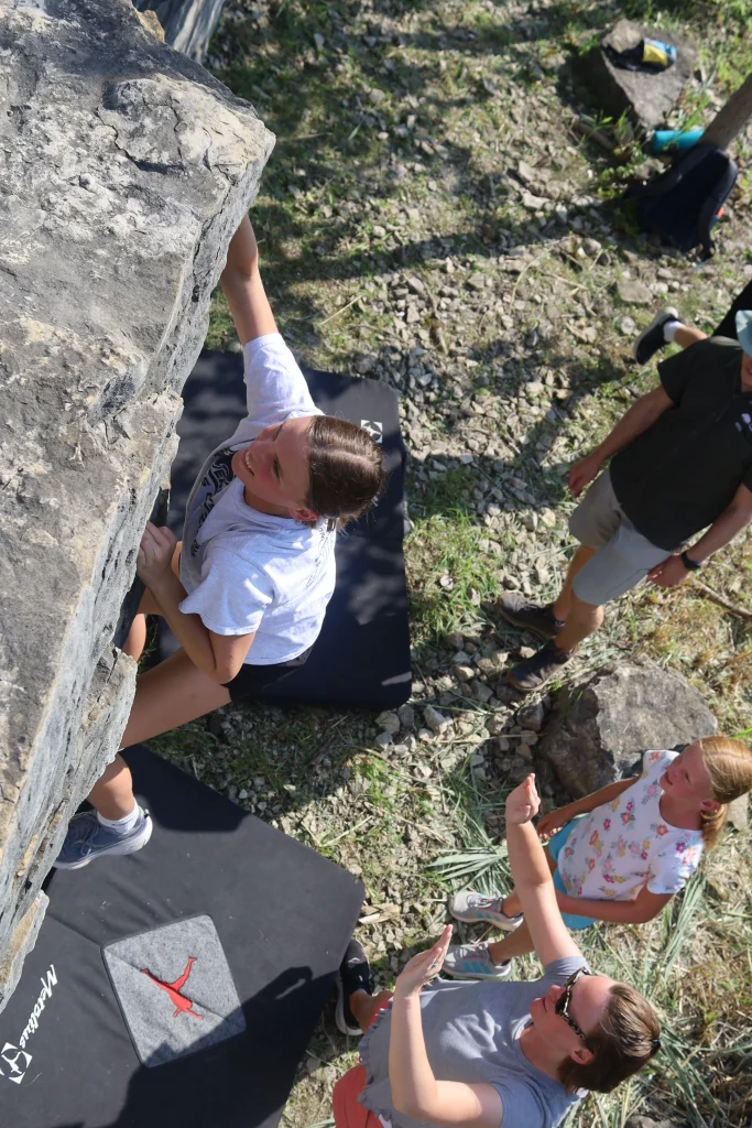 Teenage girl bouldering on a quarry ledge