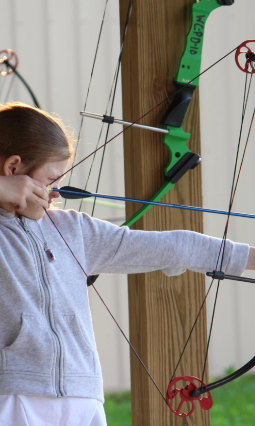 Young archer gets ready to send their arrow flying at an archery target at Arrowwood Archery Range.